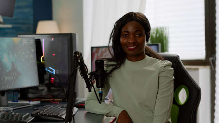 Portrait of excited african professional streamer player looking at camera smiling. Online streaming...