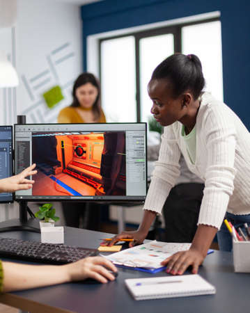 Diverse team developing project sitting in startup creative agency company using pc with two...