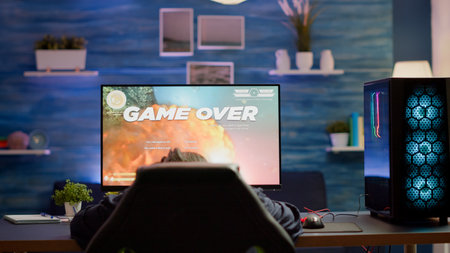 Tired pro cyber player gaming online video games on powerful personal computer with RGB lights.の写真素材