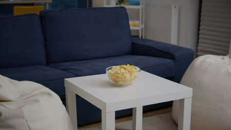 Modern empty apartament with nobody in it is ready for night party having chips bowl on woden table.の写真素材