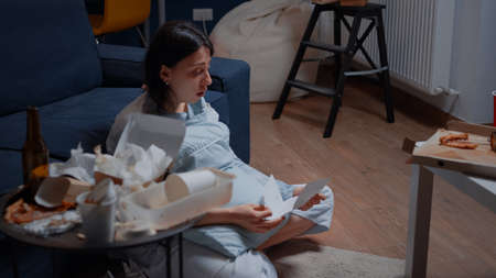 Devastated, desperate, frustrated depressed, young woman crying reading letterの写真素材