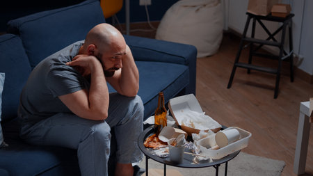 Psychotic alone unhappy, depressed, frustrated man sitting in sofaの写真素材