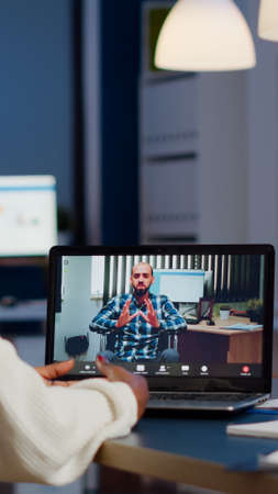 African businesswoman having corporate meeting with remotely paralyzed man using webcam of laptop...