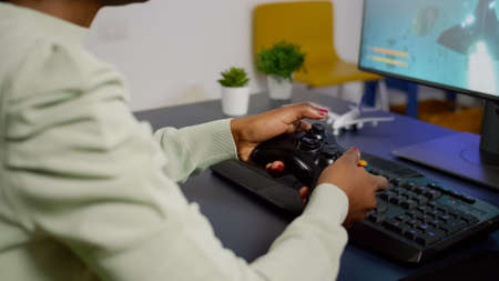 Closeup of wireless joystick and RGB keyboard, pro video gamer playing online video games on...