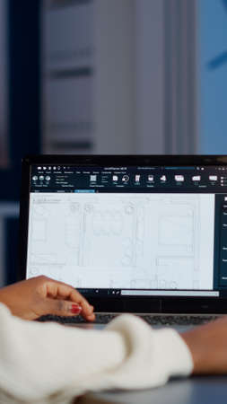 African engineer constructor designer architect analysing new bluilding plan in CAD program working...