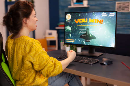 Professional gamer playing and winning in space shooter online video game on powerful computer. Pro...