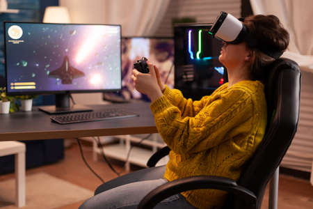 Professional gamer wearing virtual reality headset using wireless controller. Pro esport team player...