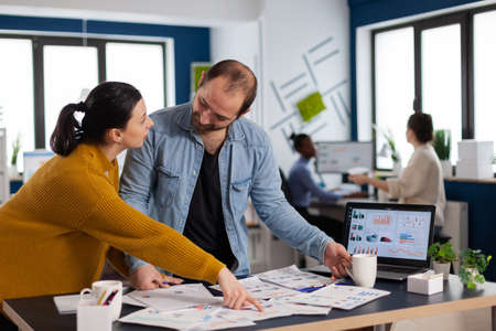 Brand manager asking for explication from employee in start up office discussion, Diverse team of business people analyzing company financial reports from computer.の写真素材