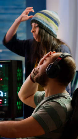 Nervous players couple losing online videogames competition using powerful computer screaming at...