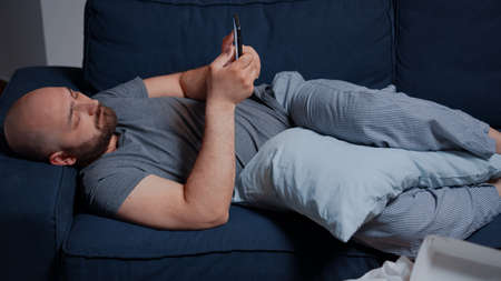 Sad unhappy depressed shocked depresive man browsing on smartphone, struggling with mental health...