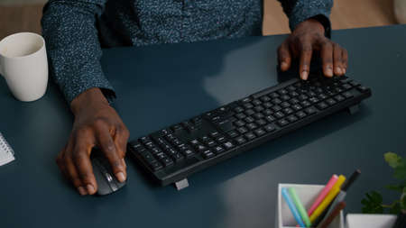 Top view of black african american person typing on PC keyboard, working from home. remote working...