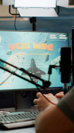 Entusiastic man gamer streamer wining space shooter video games holding joystick playing on...