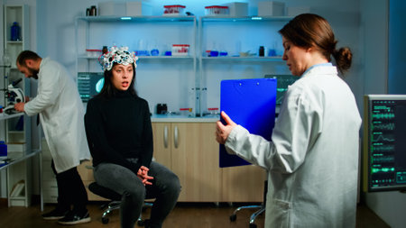 Professional doctor in neurological medicine testing eyesight of patient with eeg headset. Medical reasearcher examining evolution of treatment against diseases of nervous system in equipped labの写真素材