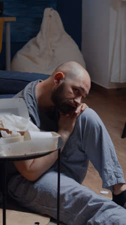 Depressed, disappointed, frustrated, ill man sitting on floor, feeling stressed, desperate having mental problems, needs psychological help, addicted heartbroken experiencing loneliness crisisの写真素材