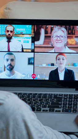 Focused adult using laptop computer during videocall conference talking about social business...