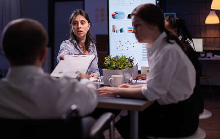 Executive manager woman explaining management statistics working at company strategy overtime in...
