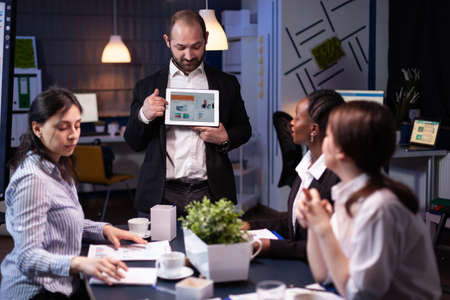 Focused businessman showing corporate graphs presentation using tablet working at company ideas....