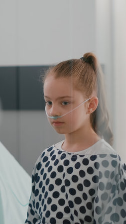 Pediatrician woman doctor listening patient lungs using medical stethoscope during recovery examination in hospital ward. Hospitalized sick girl recovering after medication surgeryの写真素材