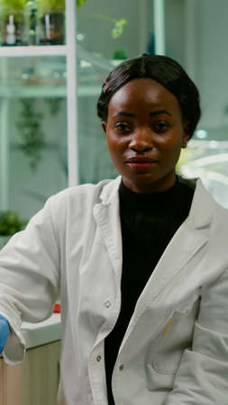 Pov of african woman sitting at desk table in pharmaceutical laboratory during online videocall...