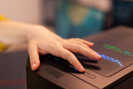 Woman gamer power on computer unit preparing for gaming tournament. Cyber performing on powerful...