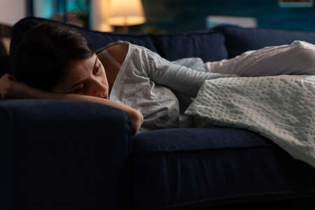 Traumatised depressed woman crying lying on sofa suffering from physical emotions, depression break...