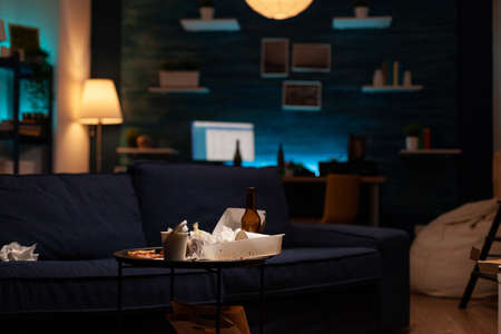 Chaotic empty living room of depressed person with scattered food mess, messy table. Unorganized...