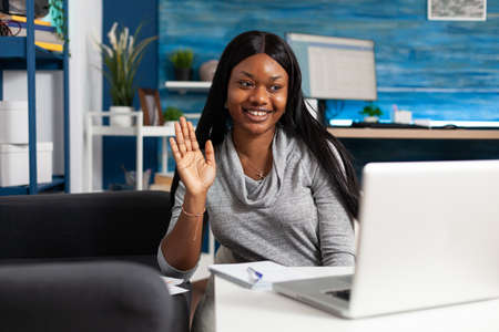 Afro american student waving academic collegue during online videocall meeting conference using...
