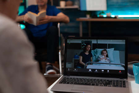 Pensioners using video call technology at home talking to sick niece and daughter in hospital ward....