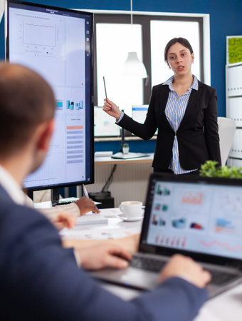 Startup female entrepreneur in business meeting with team, working in conference office group leader manager briefing project to colleagues, partners, explaining information presentation teamworkの写真素材