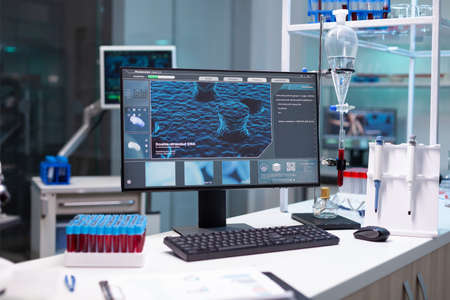 Computer with microbiology virus expertise on display standing on table during medicine biochemistry...