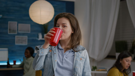 Close up of woman portrait looking into camera while drinking beer celebrating friend birthday late...