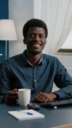 Zoom in portrait shot of african american black man freelancer smiling to camera, handsome young man...