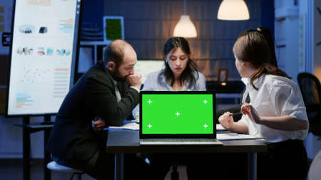 Diverse multi ethnic businesspeople planning management strategy discussing company presentation in meeting office. Mock up green screen chroma key with isolated display standing on table conferenceの写真素材