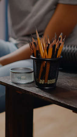 Close up of table with art tools and colorful pencils for professional drawing concept in art studio space. African american creative artist working on masterpiece canvas for projectの写真素材