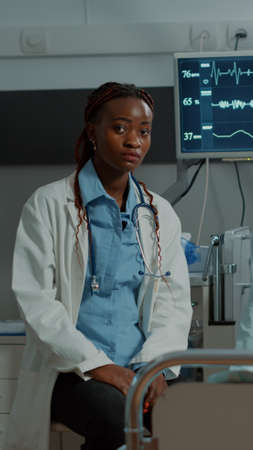 African american medic and sick patient talking in hospital ward at healing facility. Doctor...