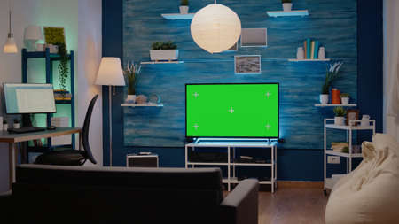 Nobody in living room with green screen display in modern decorated flat. Television with chroma key with isolated background using copy space and mockup templateの写真素材