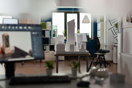 Empty architectural room for design and modern computer with blueprint plan building model maquette. Workplace for professional architect occupation with business equipment desk boardの写真素材