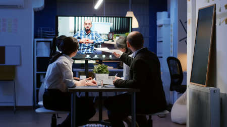 Multi ethnic businesspeople discussing with remote entrepreneur in wheelchair during online...