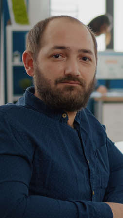 Paralized, invalid, handicapped office manager looking at camera sitting in modern startup company...