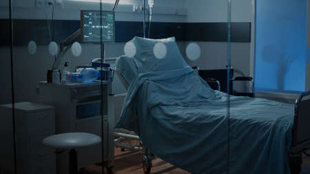 Empty intensive care room on hospital floor with nobody in bed. Emergency ward used for healing illness, surgery, disease with medical treatment, clinical equipment, recover technologyの写真素材