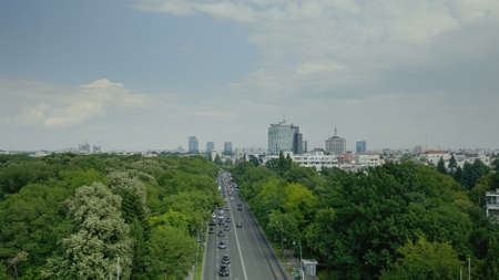 Skyline aerial landscape of metropolitan city with top view of boulevard, cars and park. Urban scene...