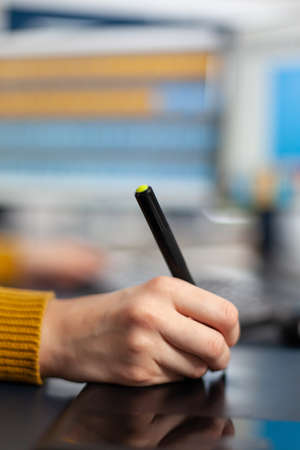 Close up hand of young woman photo drawing on graphic tablet editing customer photo on computer with...