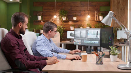Team of video editors analyzing film montage after editing visual effects working in creative...