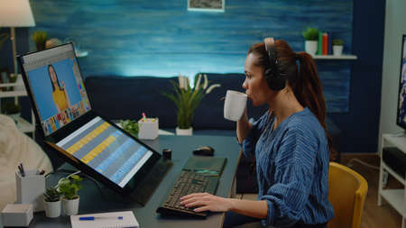 Photography artist with editing software doing edit work for media production and pictures. Professional editor using retouching software with touch screen and wearing headphones for musicの写真素材