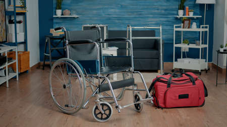 Empty nursing home room at facility for rehabilitation and healthcare. Nobody in space with wheelchair and medical equipment for elder people, giving assistance to ill patients.の写真素材