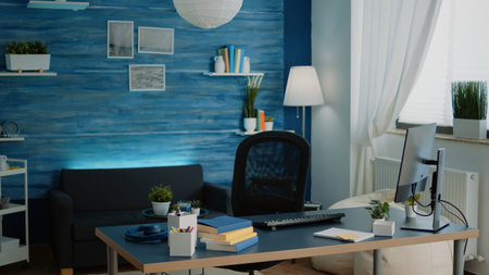 Little girl sitting at desk using computer and keyboard for school work at home. Concentrated pupil with homework looking at monitor on internet connection for remote online lessons.の写真素材