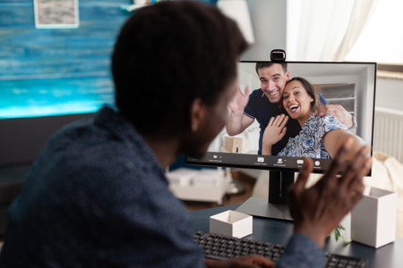 Student greeting remote friends discussing management project ideas during online videocall meeting conference in living room. Man having virtual videoconference call during coronavirus lockdownの写真素材