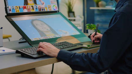 Close up of photographer hands using retouching software on touch screen computer. Photography artist with graphic tablet and stylus editing pictures with professional equipment.の写真素材