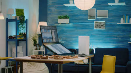 Man architect using touch screen monitor with building model on display. Engineer working on...