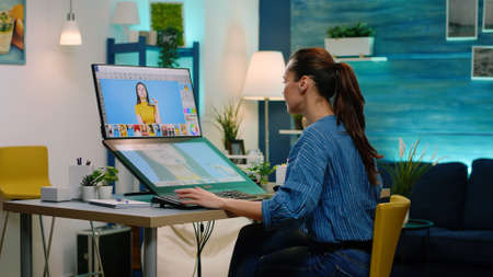 Woman photographer using touch screen computer on retouching software for pictures. Photography...
